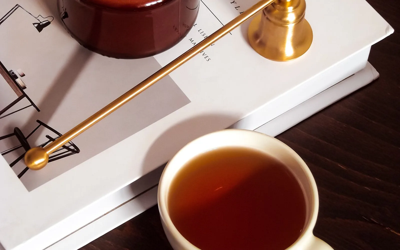 Taza de té junto a un libro, ambiente de noche